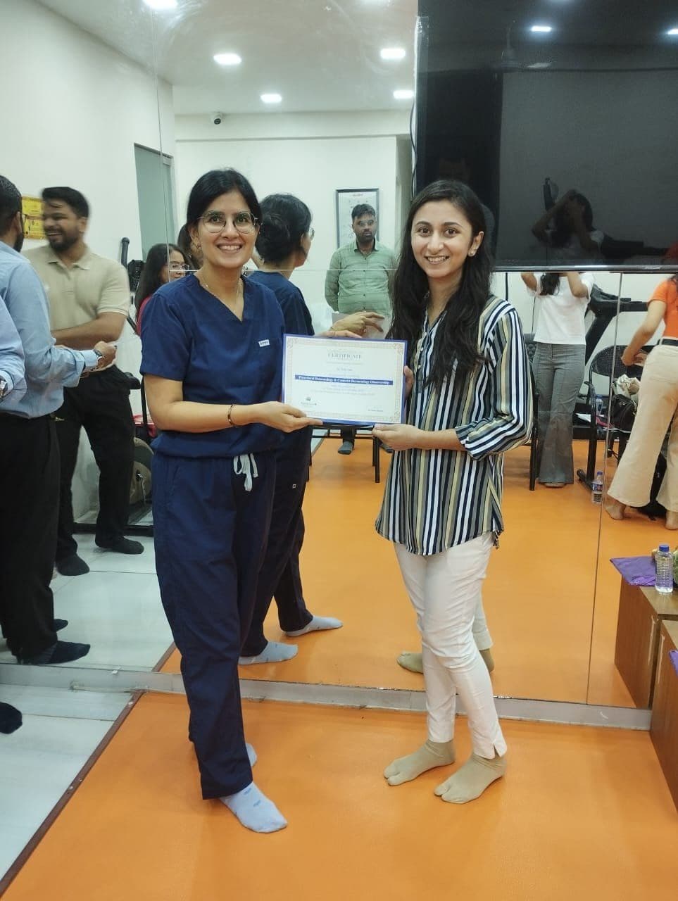 Dr. Neha Shukla presenting certificate — graduate 12