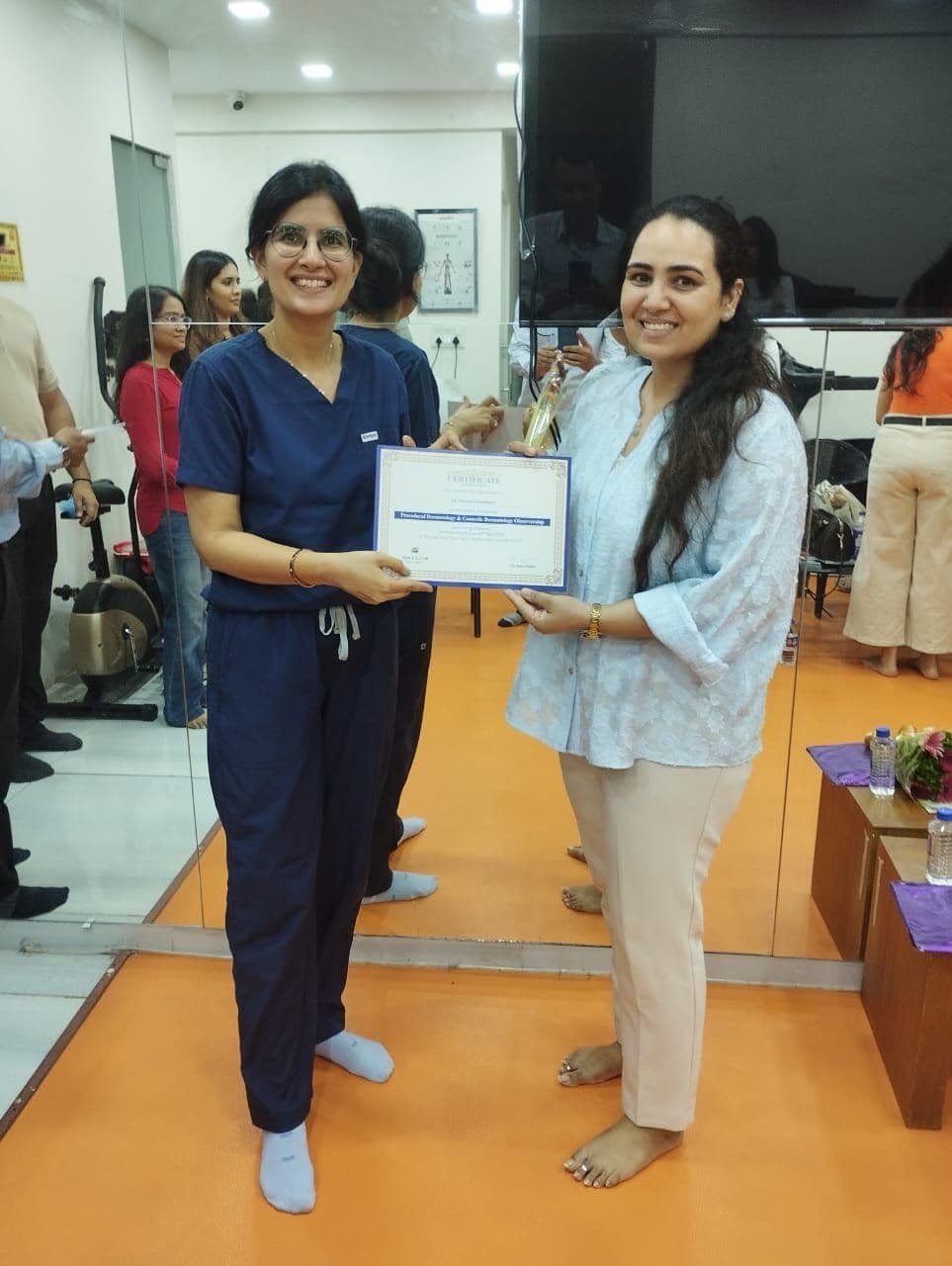 Dr. Neha Shukla presenting certificate — graduate 2